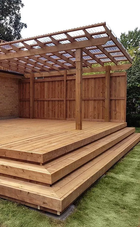 Cedar deck with stairs and a pergola in a private backyard