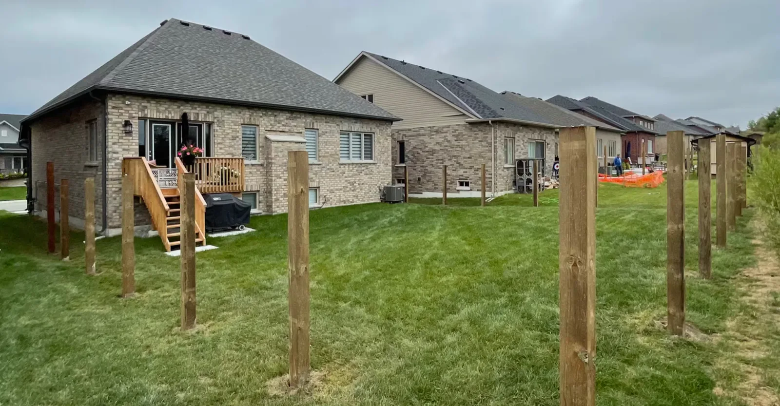 Full run of wooden fence posts set behind new homes