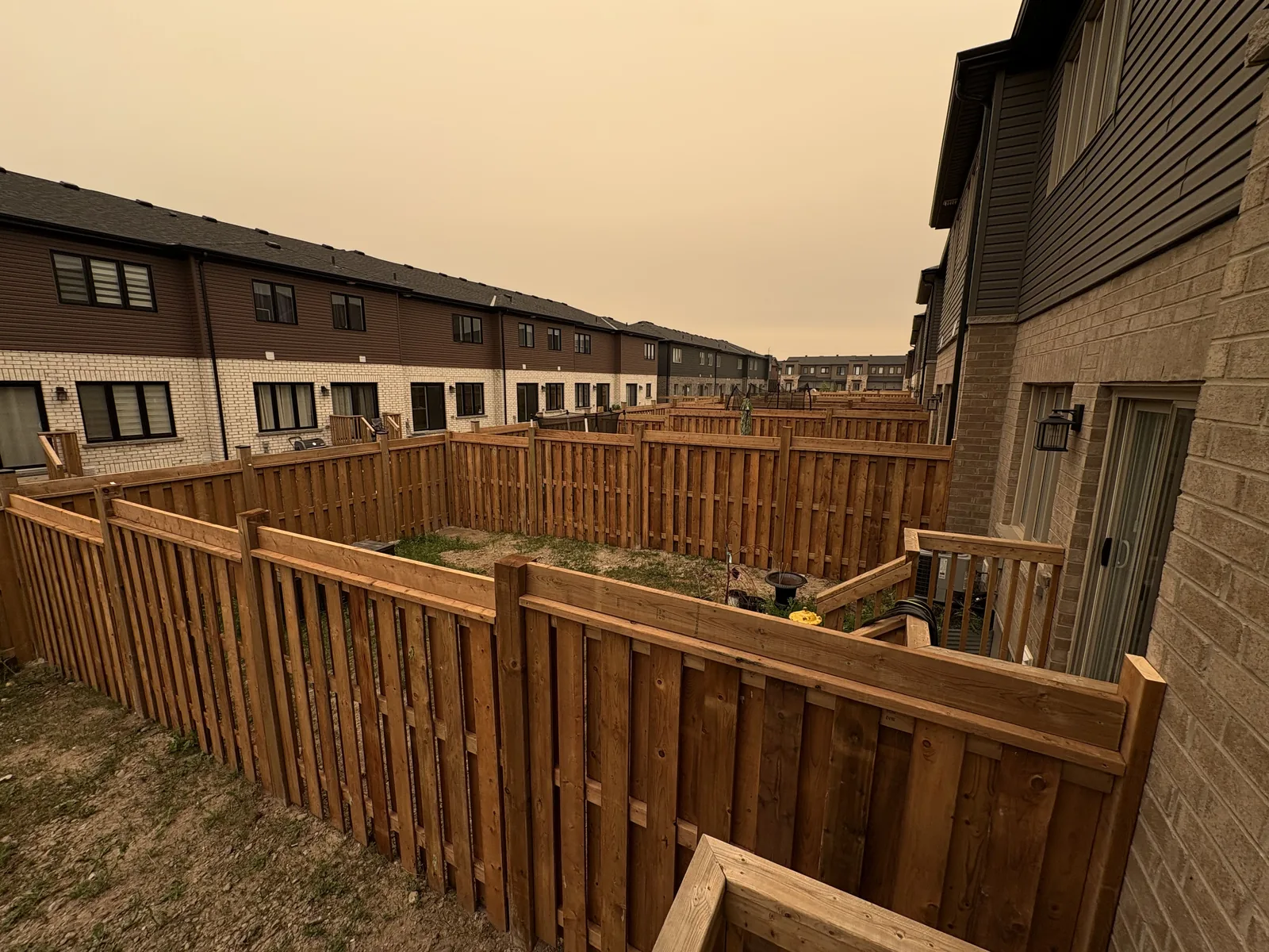 Cedar privacy fence run dividing a block of new townhouse backyards